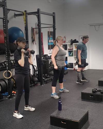 A small group session working with dumbbells in the studio