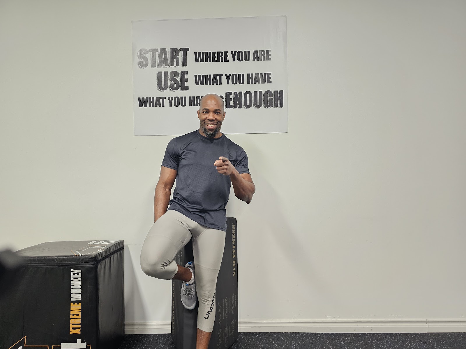 Gbenga in the studio in front of the Start Where You Are sign
